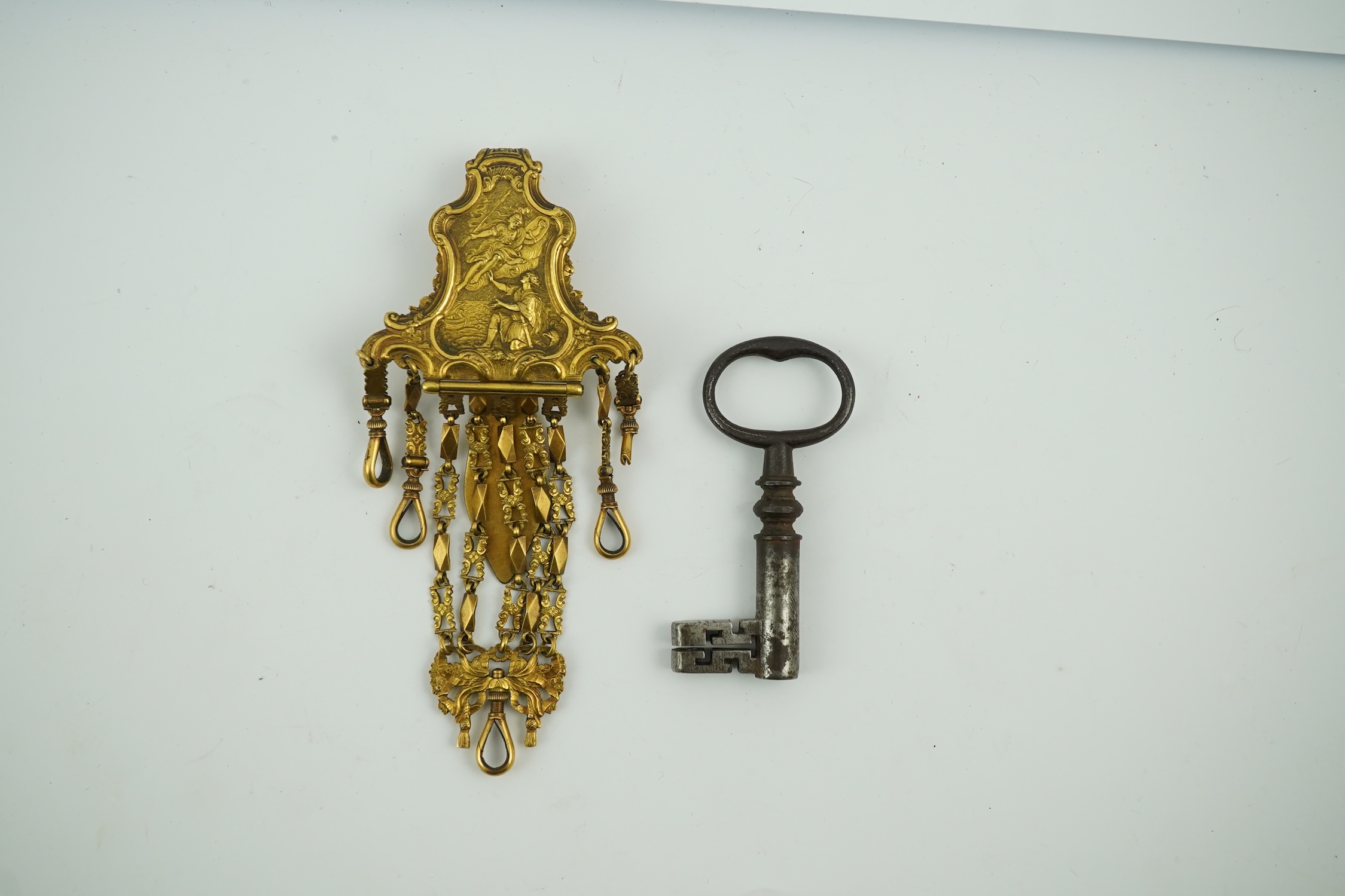 A late 18th century German gilt metal chatelaine and a steel key, chaterlaine 14cm long. Condition - a link is missing on one chain